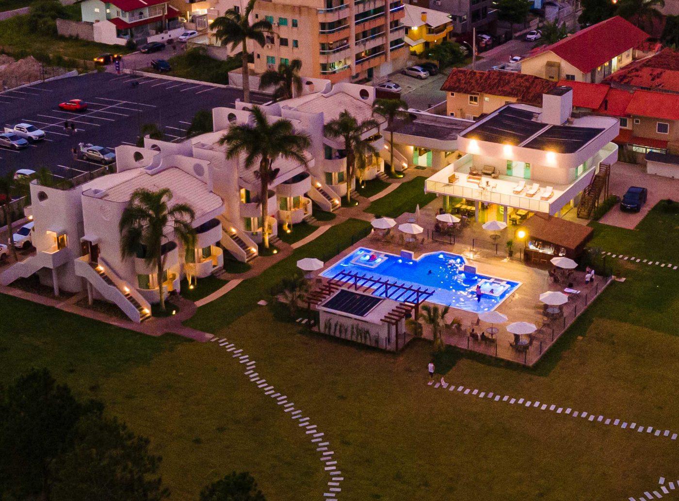 Vista aérea do Makkai Resort ao anoitecer, com a piscina iluminada